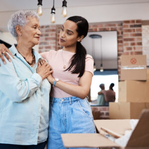 Senior woman packing up her belongings with her adult daughter in preparation for a move to assisted living.